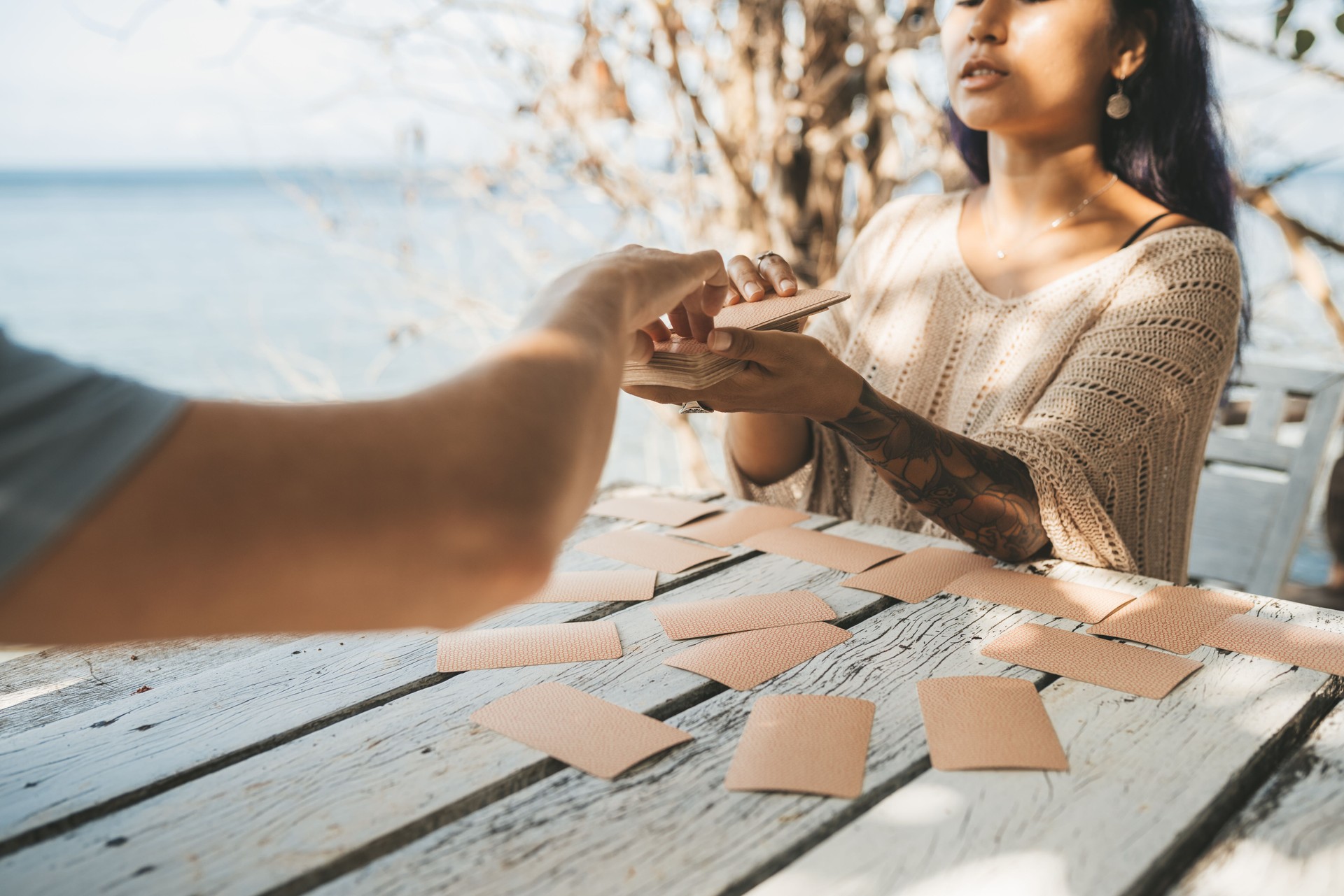 Woman is reading Tarot cards with a customer outdoors